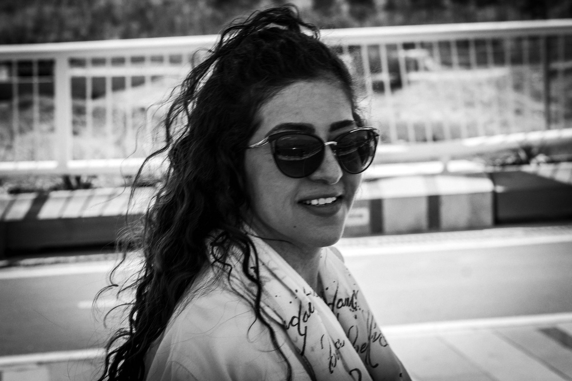 Une femme en lunettes de soleil qui rit par-dessus son épaule