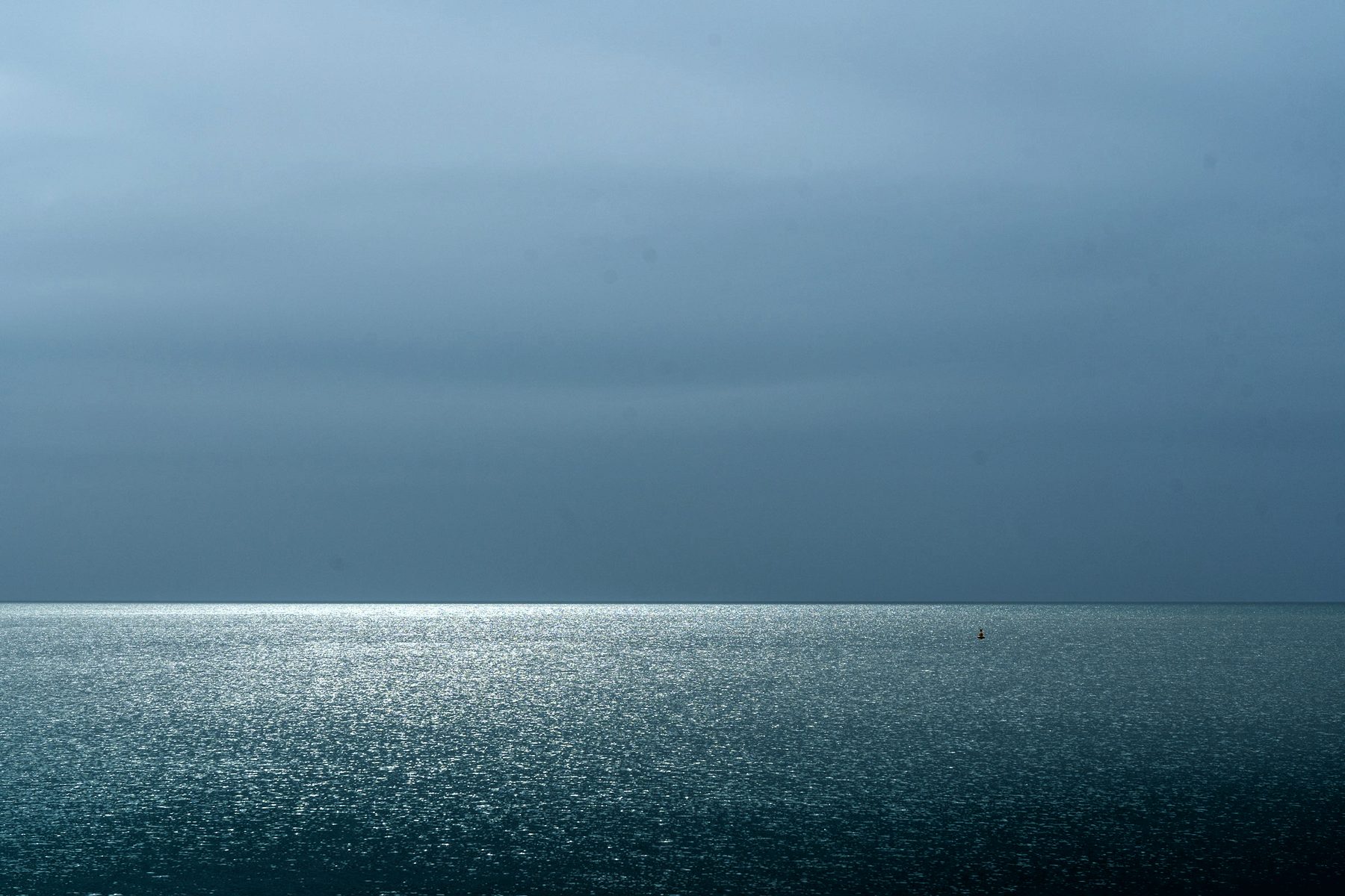 Une mer plate sous un ciel couvert